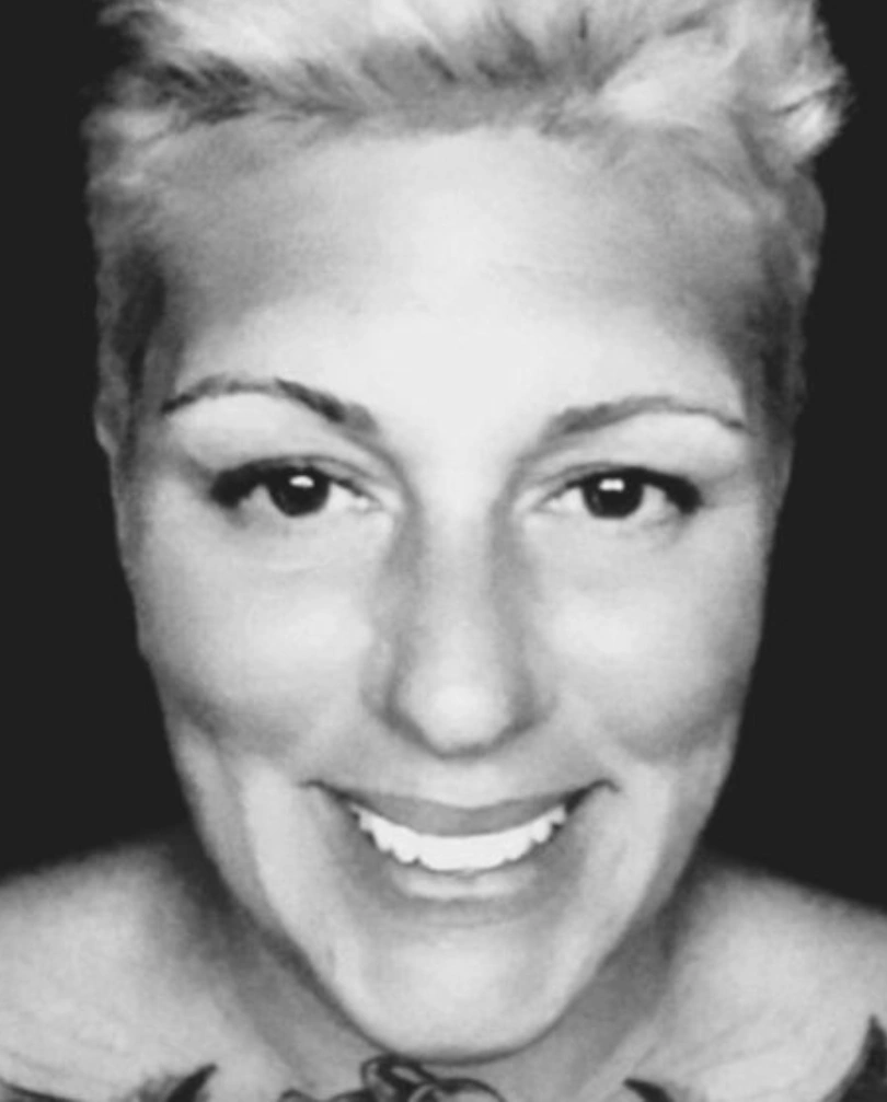 Black and white close-up portrait of a smiling woman.