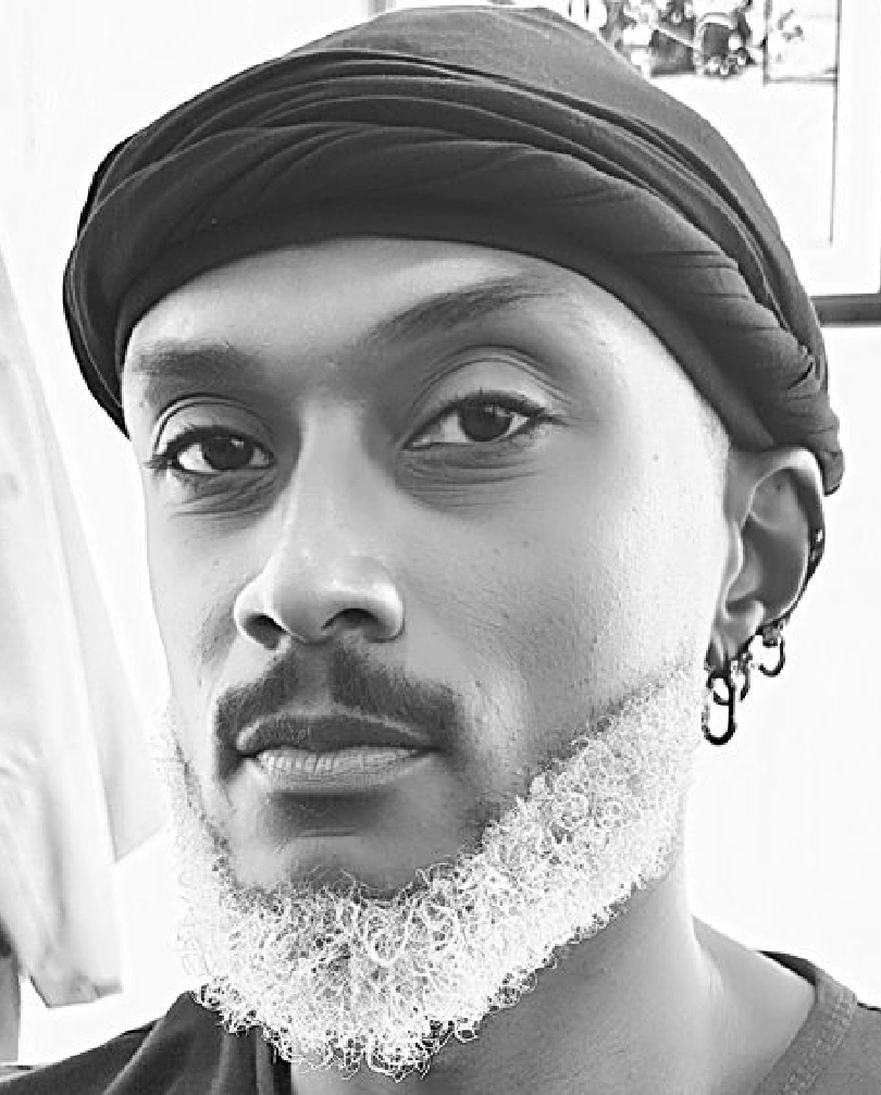 Black-and-white portrait of a man with a beard and headwrap.